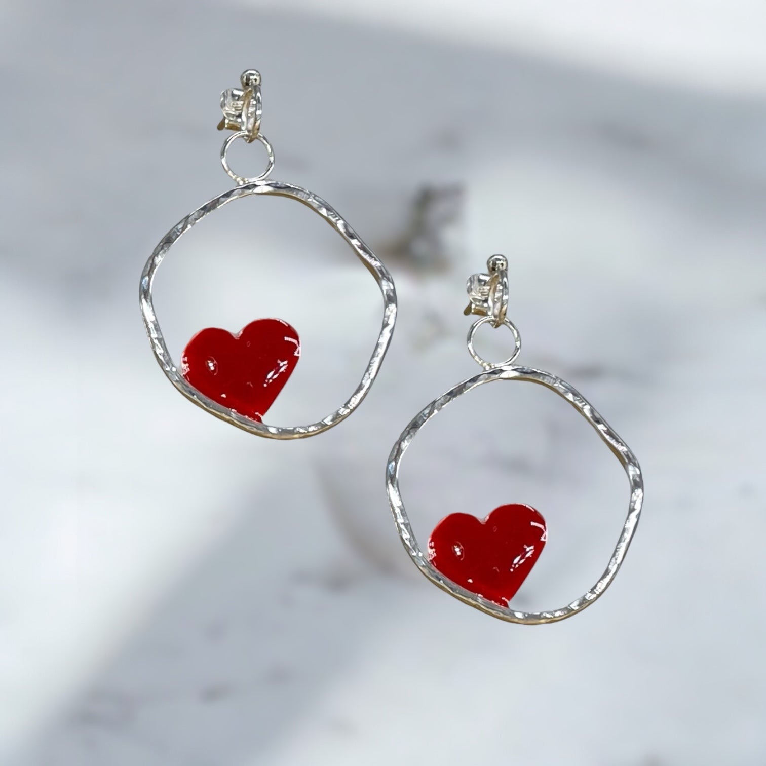 Orecchini artigianali in argento battuto con cuore smaltato